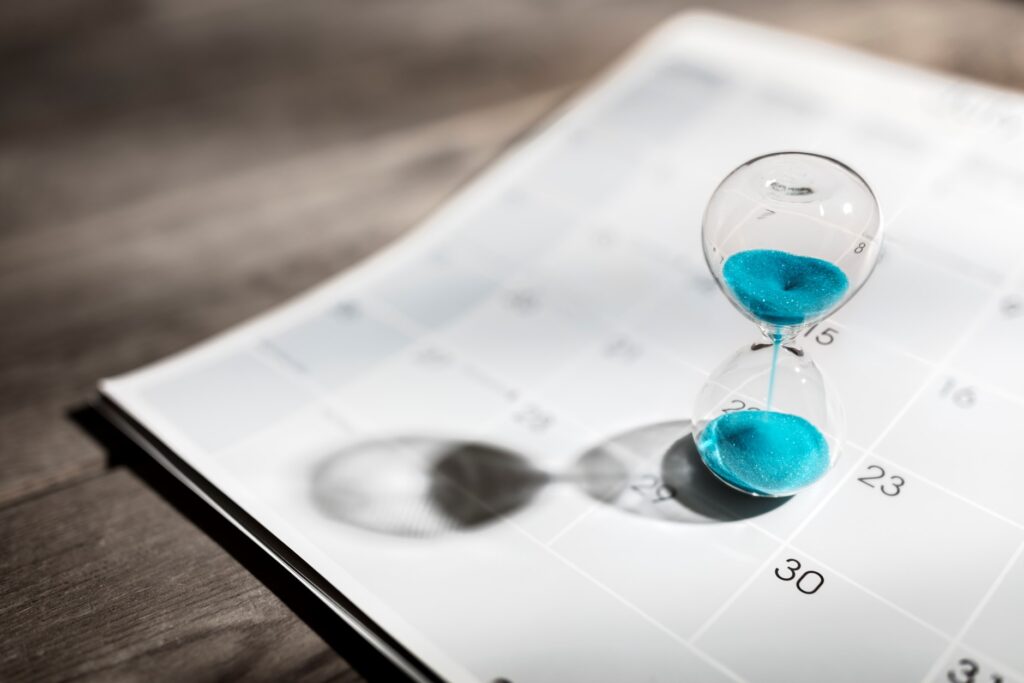 hourglass emptying on a calendar, depicting someone wasting time waiting in an office